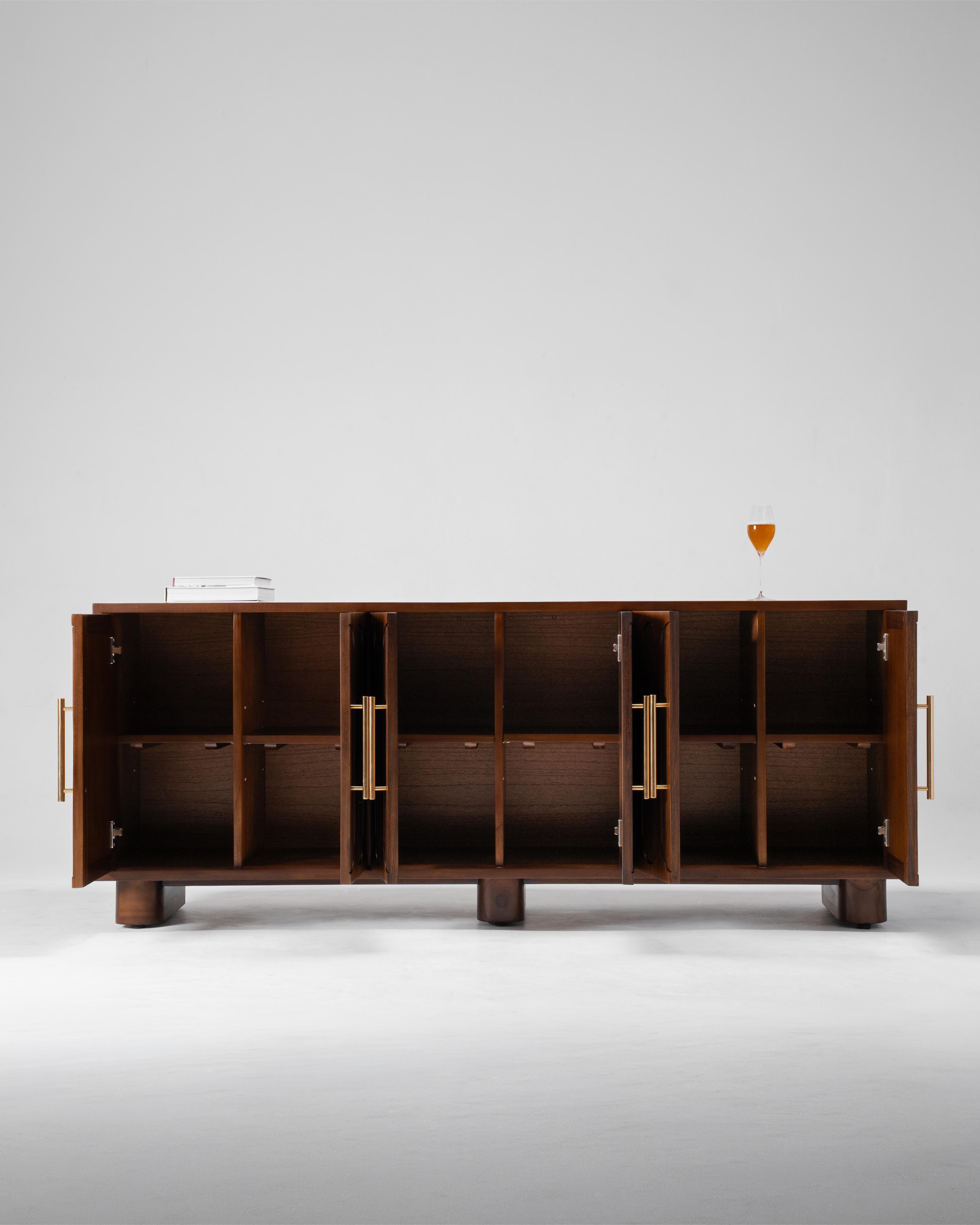 A mid-century modern wooden sideboard cabinet with open doors, featuring brass handles