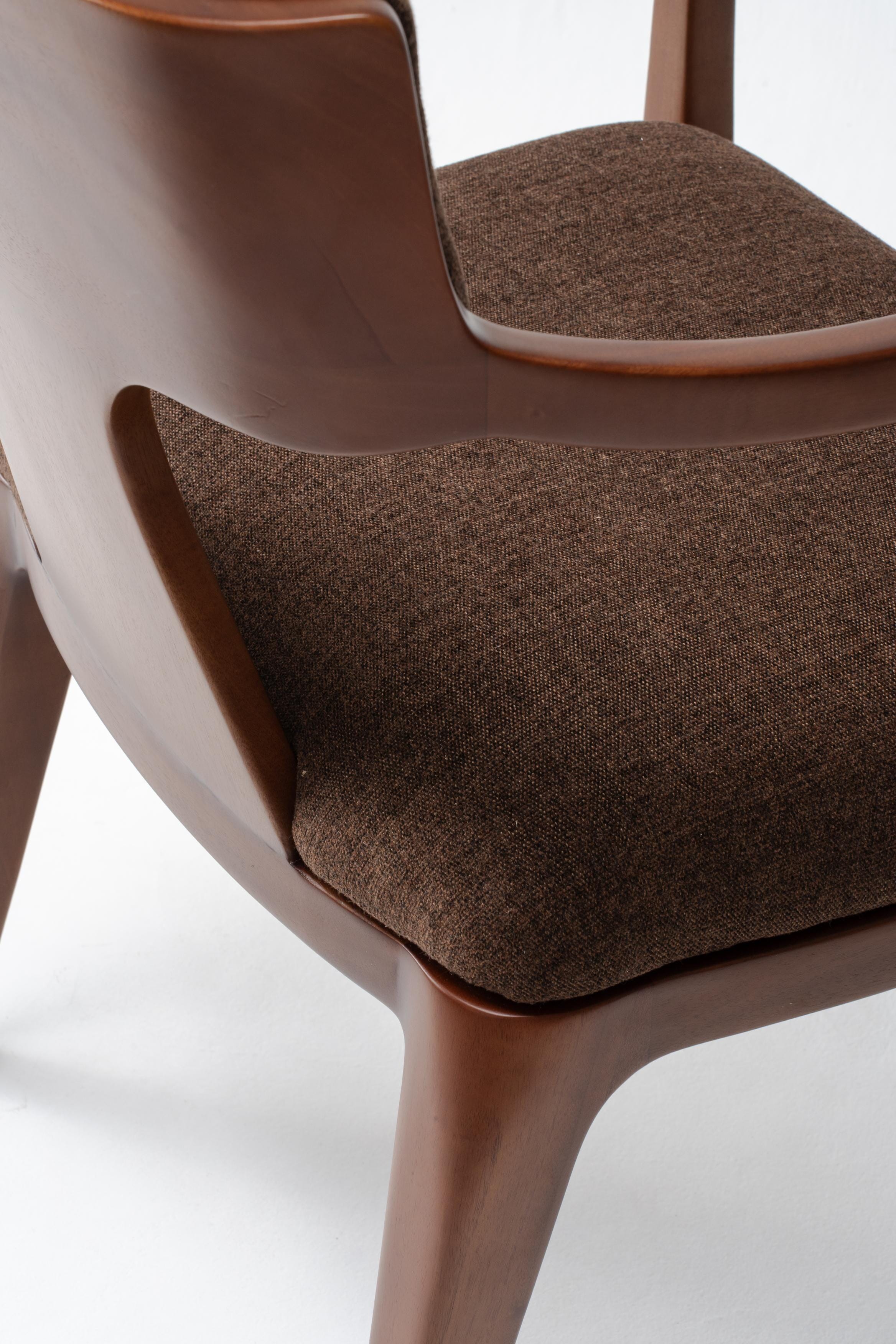 Brown upholstered chair with timber frame on a white background