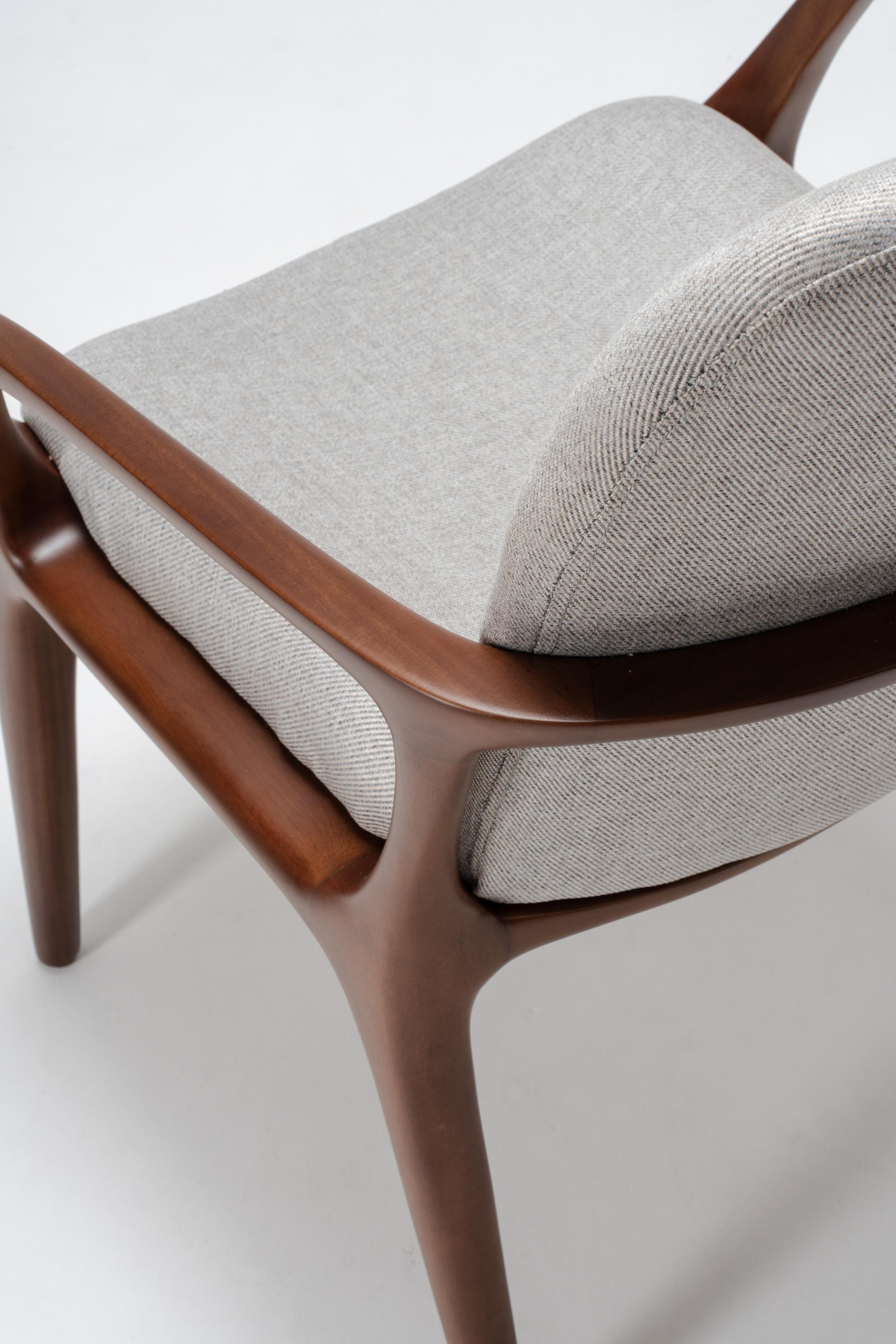 Chair with mahogany wood frame and grey cushion on a white background