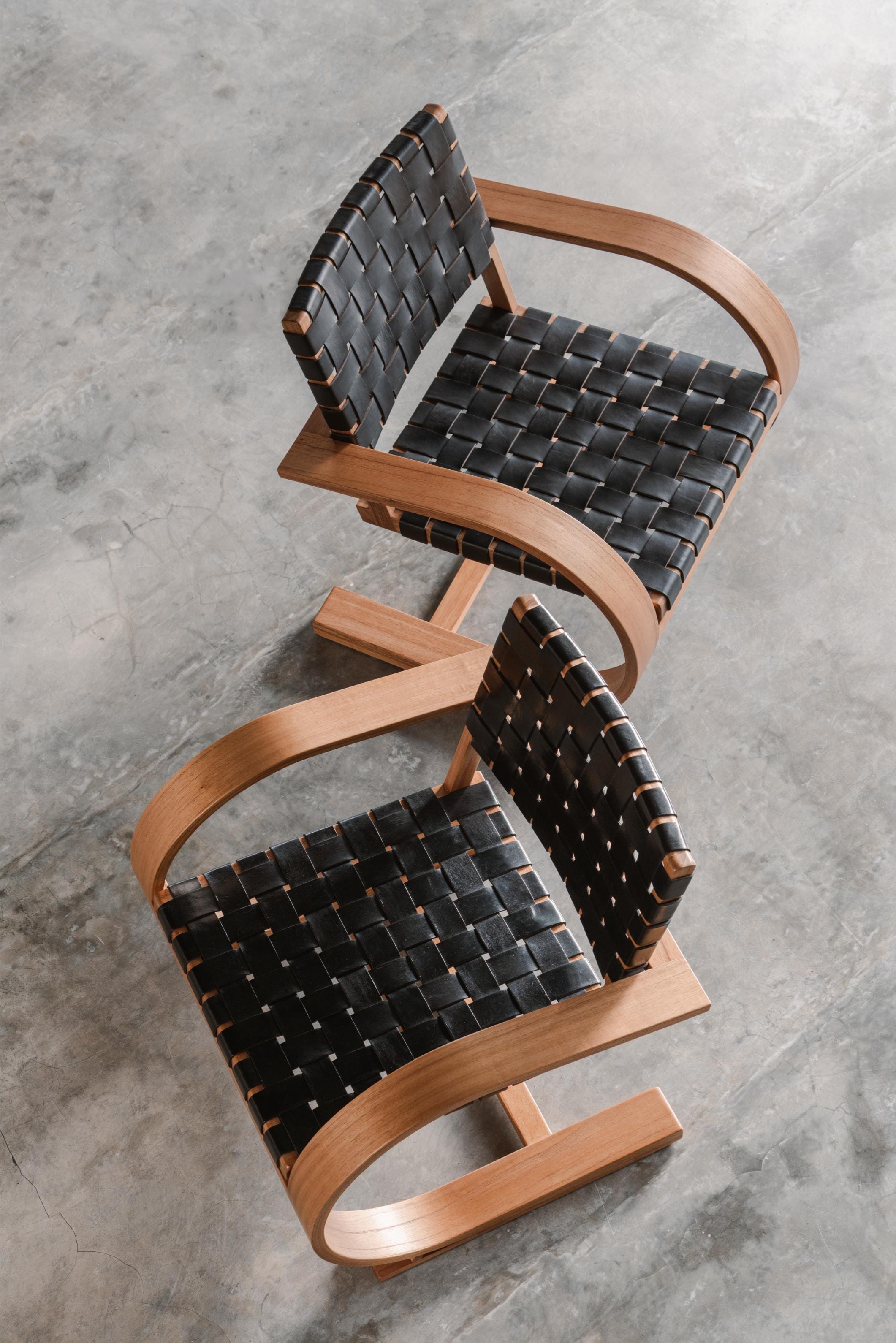 two black leather and timber armchair