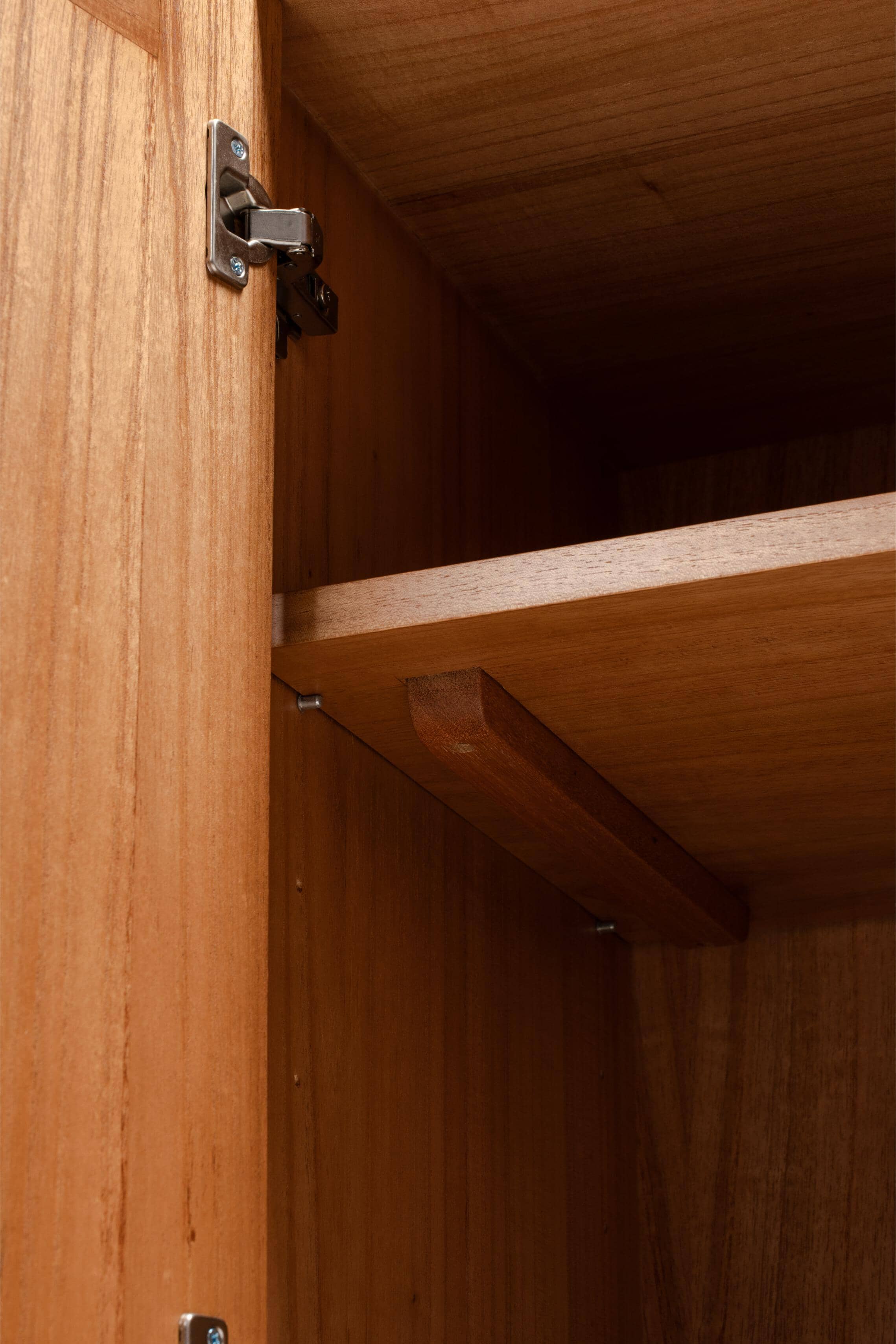 Wooden cabinet with open door showing hinge and adjustable shelves