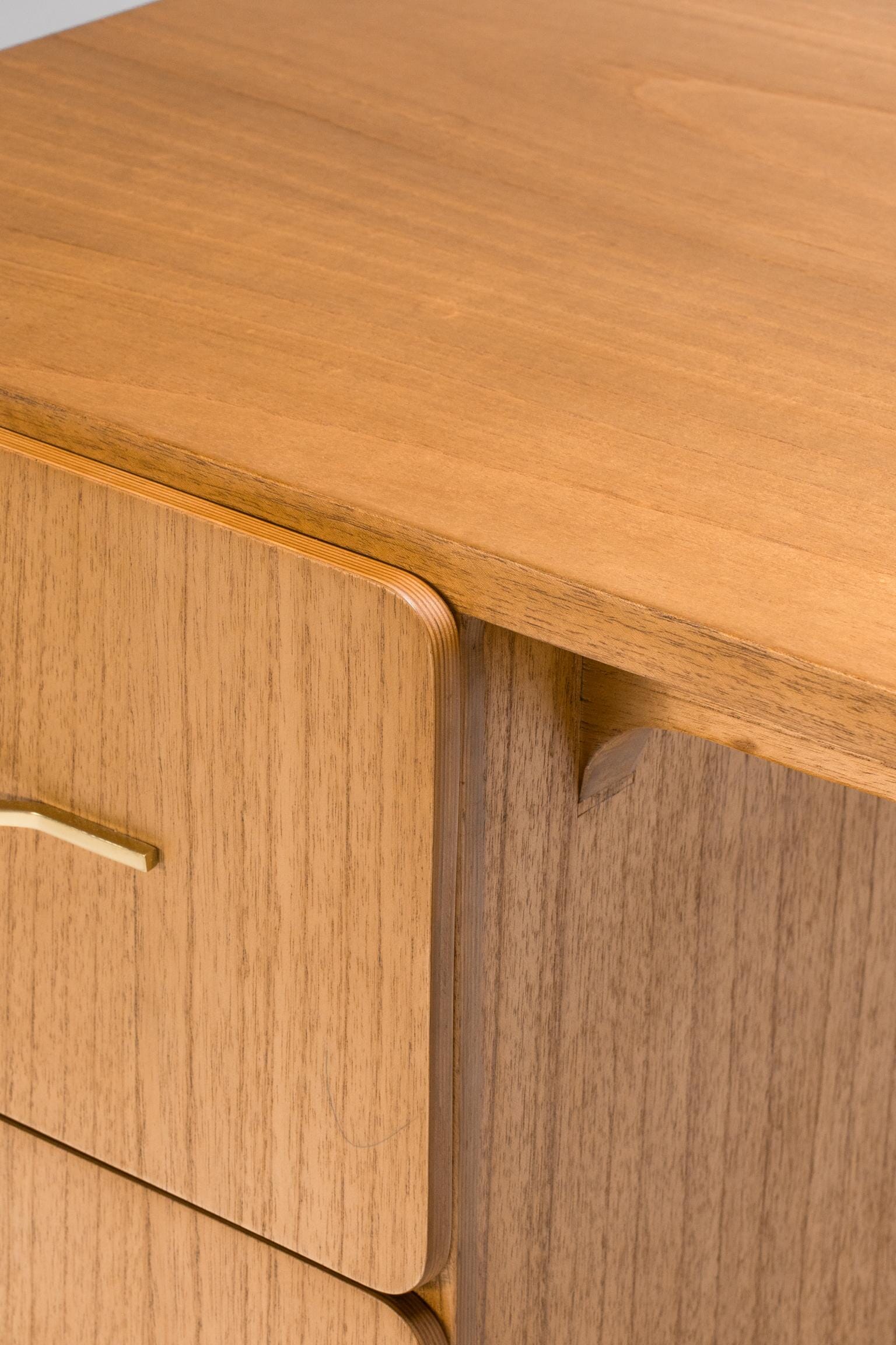 Close-up of a wooden drawer with a light wood finish