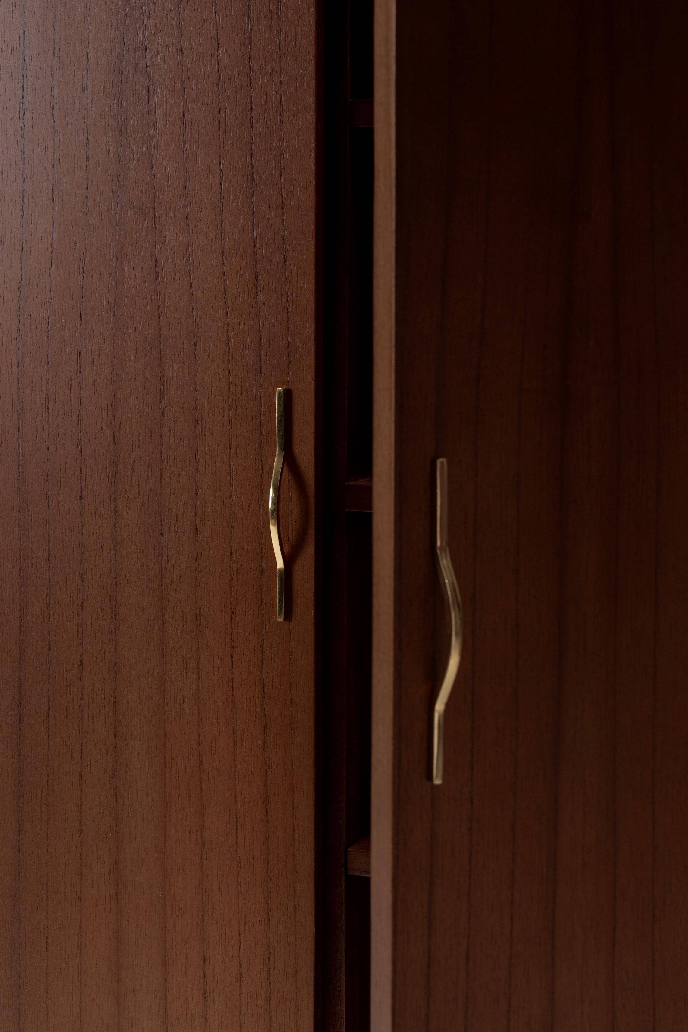 Close-up of a wooden cabinet with brass handles