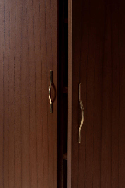 Close-up of a wooden cabinet with brass handles