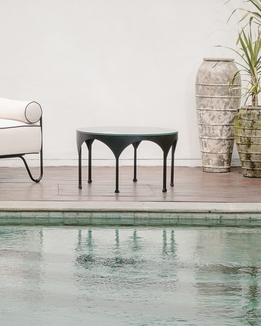 Modern outdoor furniture by a pool with greenery
