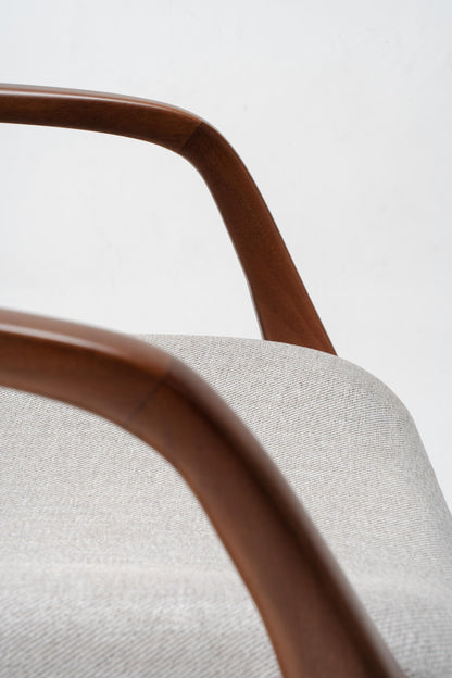 Close-up of a chair with wooden armrests and grey cushioned seat 