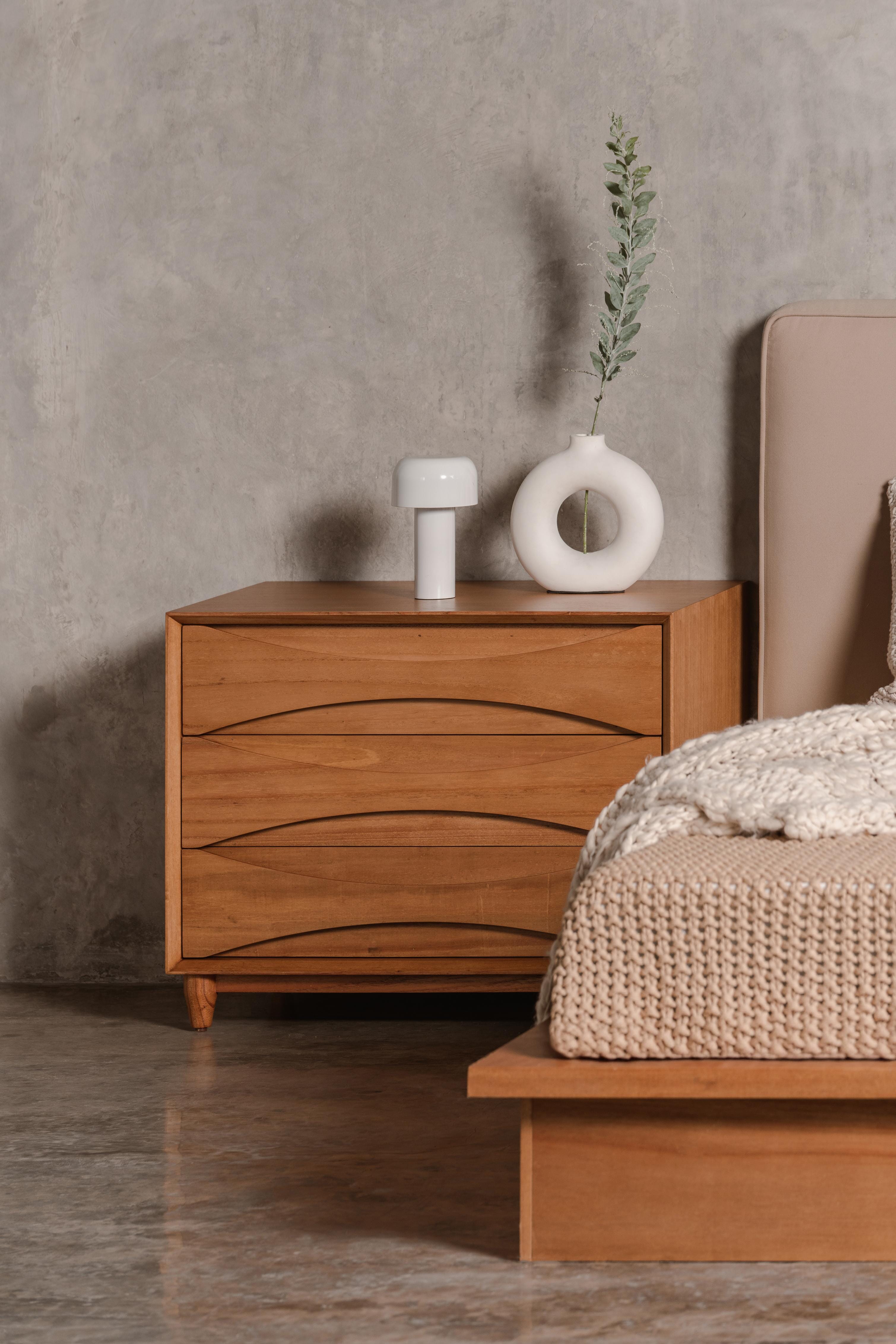 Wide wooden nightstand in a bedroom setting
