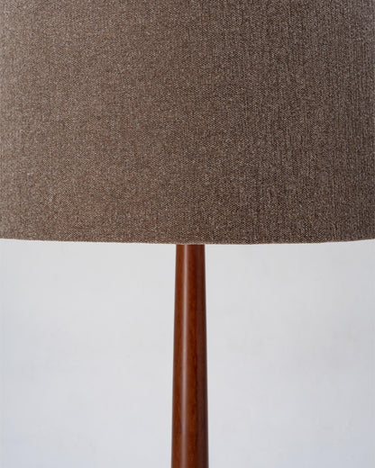 Close-up of a lamp with a brown fabric shade and wooden base